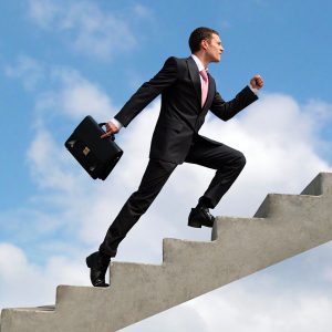 Image of confident businessman with briefcase walking upstairs